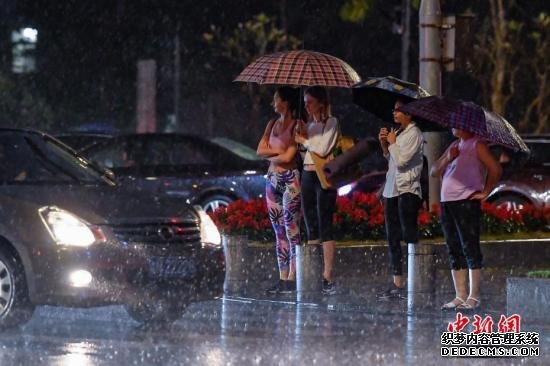 4月11日晚，街头行人撑伞挡雨。当晚，广州市区出现强降水和雷雨大风等强对流天气。<a target='_blank'  data-cke-saved-href='http://www.chinanews.com/' href='http://www.chinanews.com/'>中新社</a>记者 陈骥旻 摄