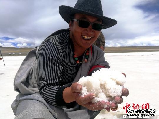 图为阿里地区革吉县盐湖乡村民在卡庆措盐湖手工采盐，当地依靠发展传统盐湖产业助力经济发展。(资料图) 赵延 摄