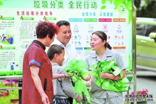 6月19日，小区垃圾分类引导员王艳向居民发放垃圾袋，普及垃圾分类知识