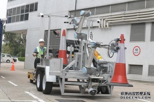 香港路政署与生产力促进局研发智能机械臂，能认知四周环境，在道路上自动放置和收回交通圆筒及危险警告灯。图片来源：香港特区政府新闻网