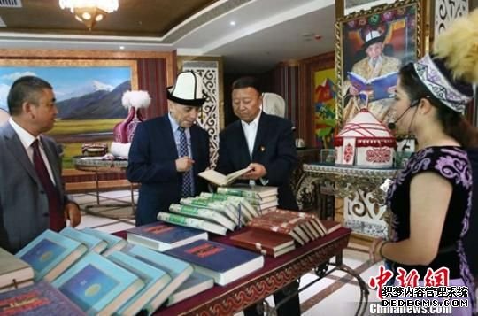 新疆克州州委常委、宣传部长金平钰(右二)为吉尔吉斯斯坦“卡巴尔”国家通讯社社长库班内奇别克(左二)介绍《玛纳斯》多版本诗集。　翟汝增 摄