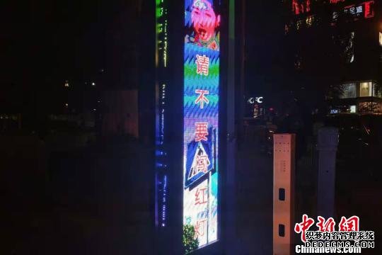 图为“空地一体化行人过街系统”的人脸识别系统抓拍到的闯红灯市民，市民的人脸特写在灯体LED屏上显示。　鲁丹阳 摄