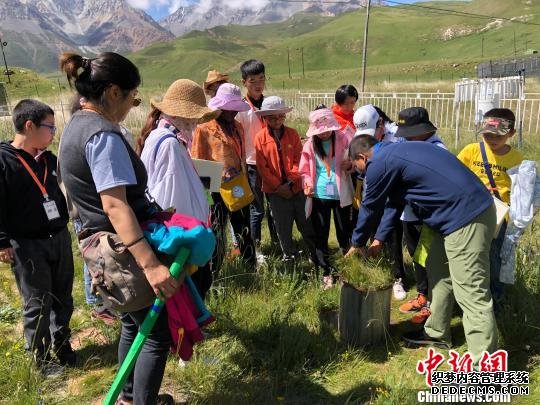 图为祁连山国家公园青海片区开设的“自然生态教育课”现场，师生们了解气象观测仪器。　钟欣 摄