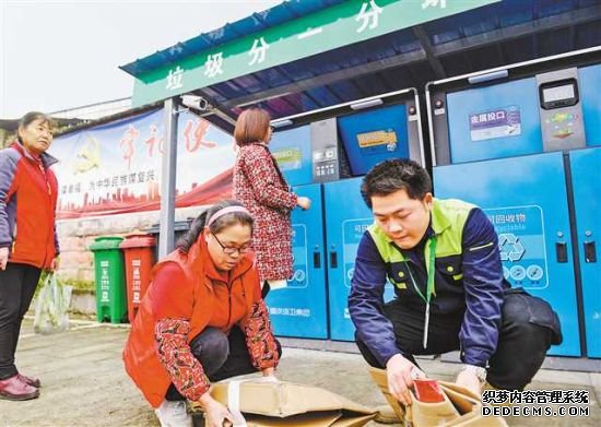 十一月二十八日，永川区黄瓜山村可回收物集中收集点，分类巡检员等协助村民往智能生活垃圾分类箱里投放垃圾。记者 张锦辉 摄